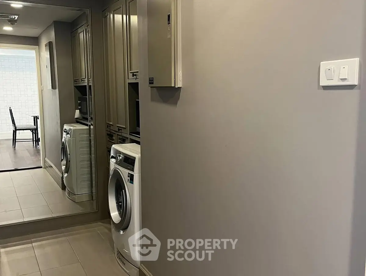 Modern laundry area with washing machine and mirrored cabinets