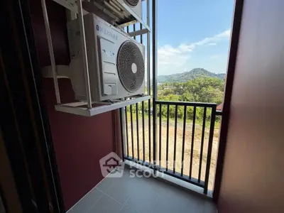 Compact balcony with air conditioning units and scenic mountain view.