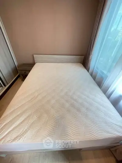 Cozy bedroom with natural light and modern furnishings, perfect for relaxation.