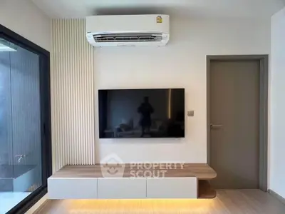 Modern living room with sleek TV setup and air conditioning unit, featuring minimalist design and natural lighting.