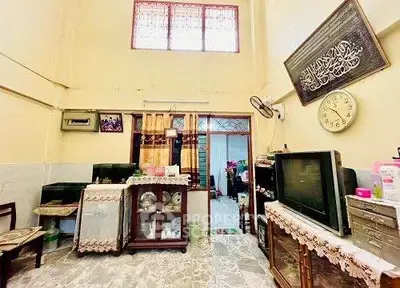 Charming living room with high ceiling and vintage decor, featuring a cozy seating area and classic furnishings.