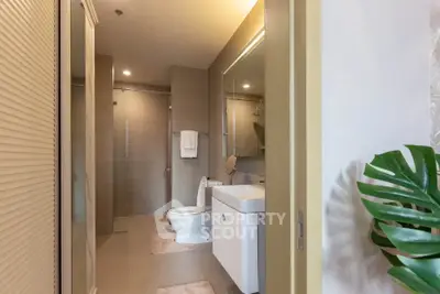 Modern bathroom with sleek fixtures and neutral tones, featuring a spacious shower and elegant vanity.