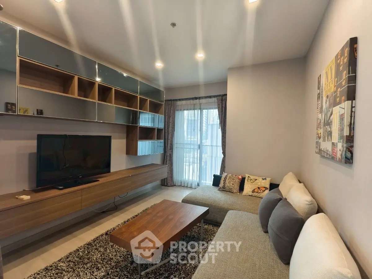 Modern living room with stylish furniture and large TV, perfect for relaxation.