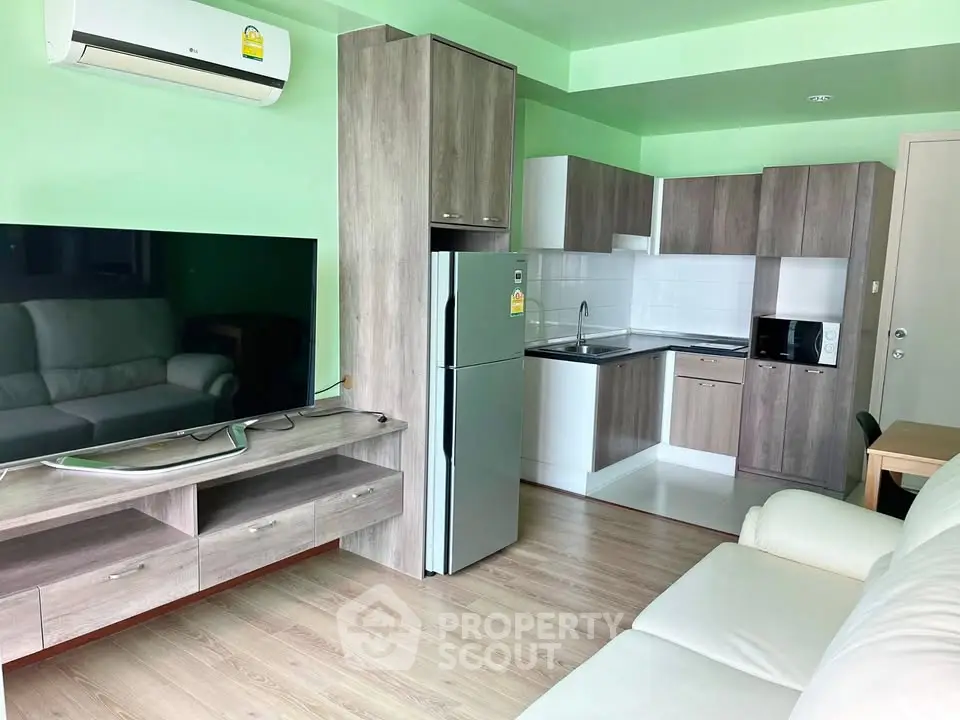 Modern living room with open kitchen, featuring sleek appliances and stylish wooden cabinetry.