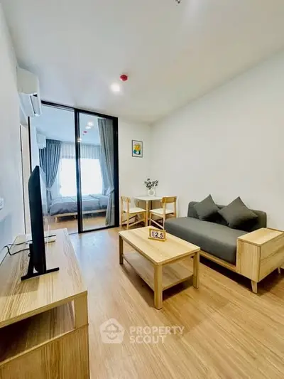 Modern living room with wooden furniture and open view to bedroom