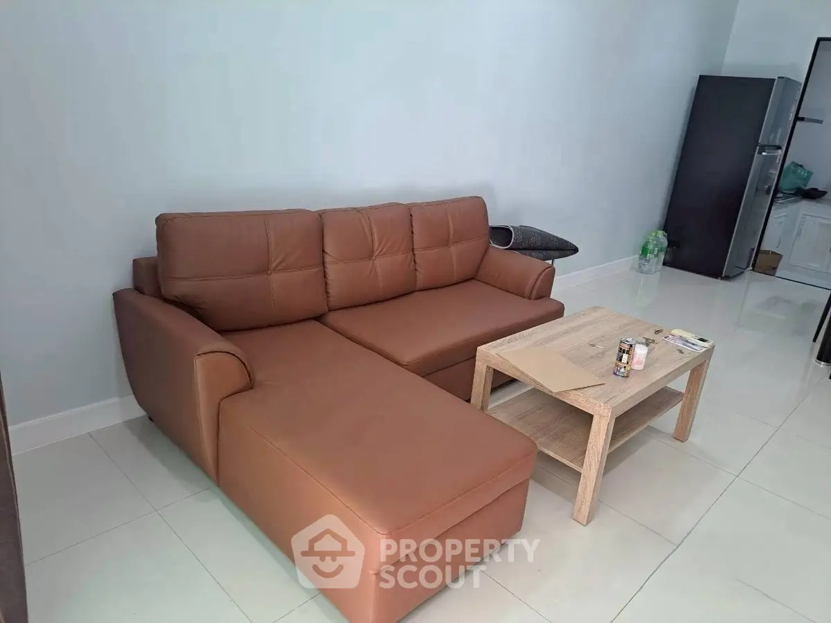 Modern living room with brown leather sofa and wooden coffee table, perfect for cozy relaxation.