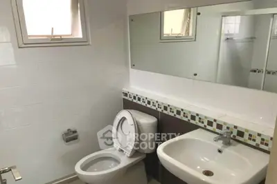 Modern bathroom with sleek fixtures and large mirror in a contemporary home.