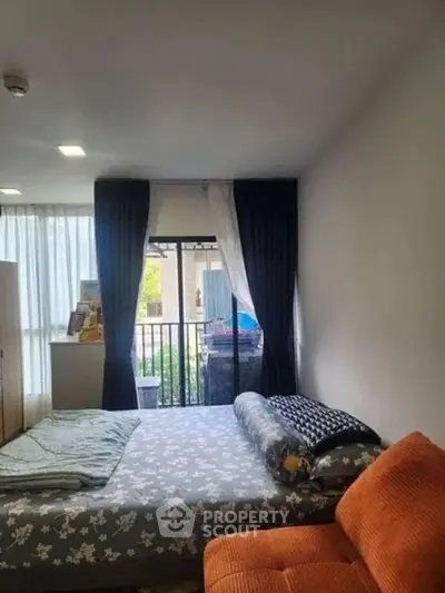 Cozy bedroom with natural light and balcony view, featuring a comfortable bed and stylish curtains.