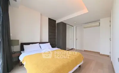 Spacious modern bedroom with wooden flooring and large windows