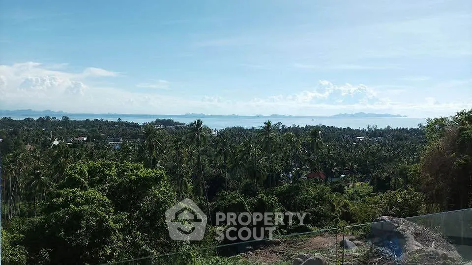 Stunning panoramic view of lush greenery and ocean horizon from a high vantage point, perfect for serene living.