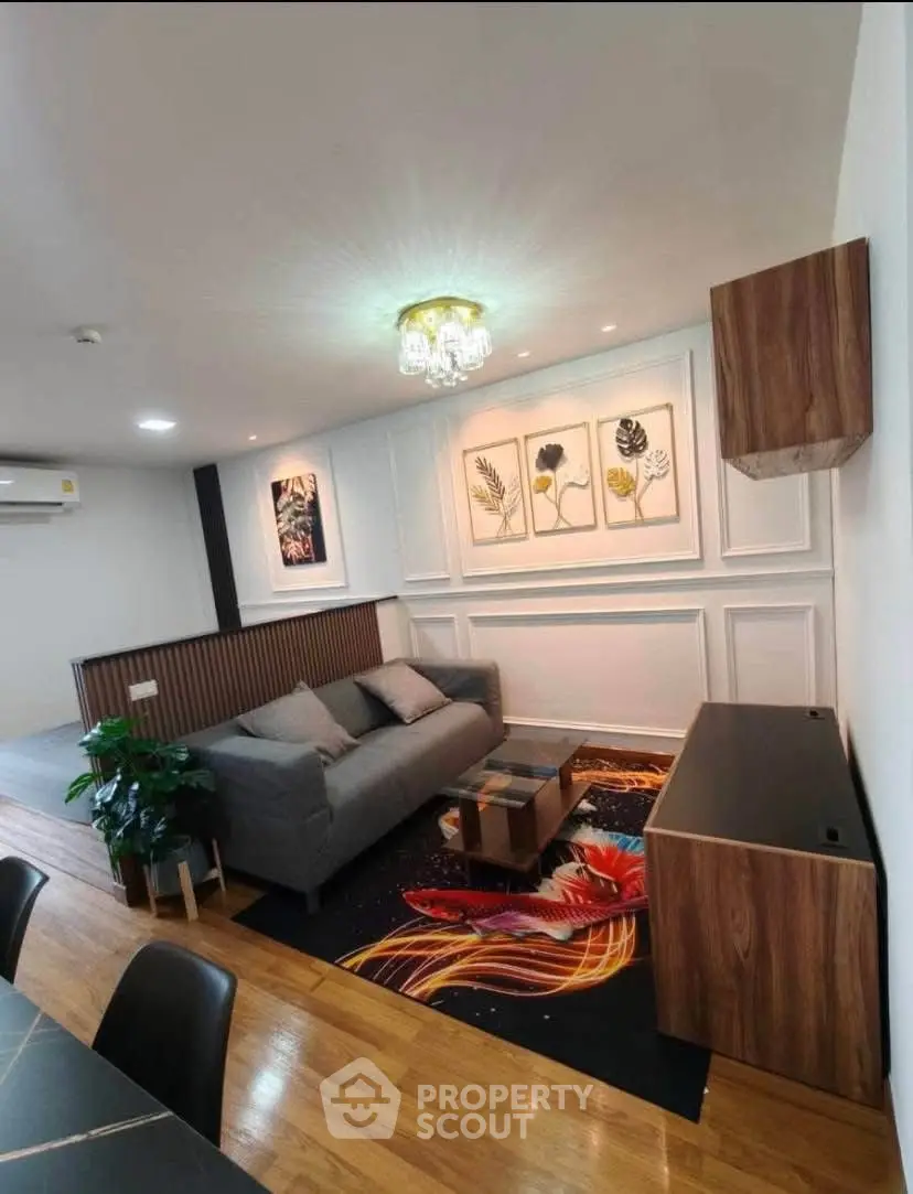 Stylish living room with modern decor and vibrant rug, featuring elegant wall art and cozy seating.