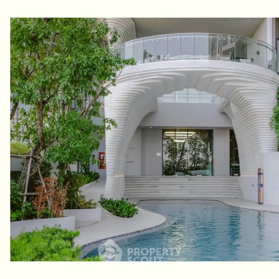 Stunning modern building exterior with unique architecture and inviting pool area.