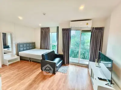 Spacious studio apartment with modern furnishings and balcony view