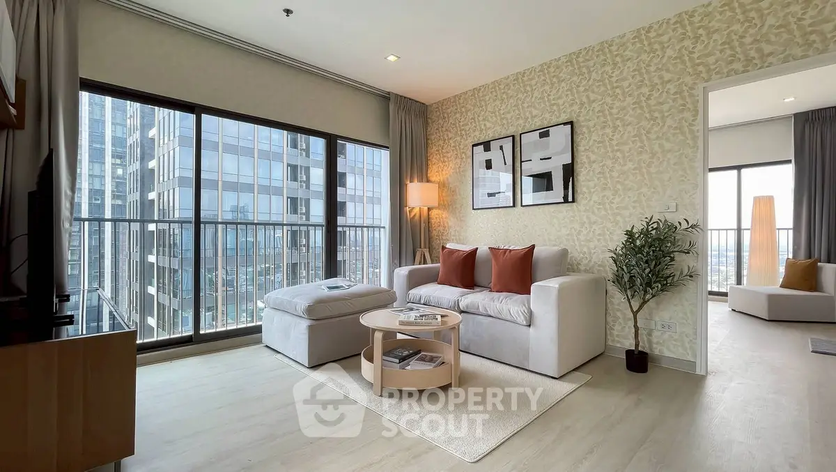 Modern living room with large windows and city view, featuring stylish furniture and elegant decor.