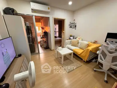 Cozy living room with modern decor and open view into bedroom, featuring stylish furniture and warm lighting.