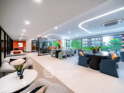 Luxurious open-plan living area with modern furniture and city views, perfect for entertaining.