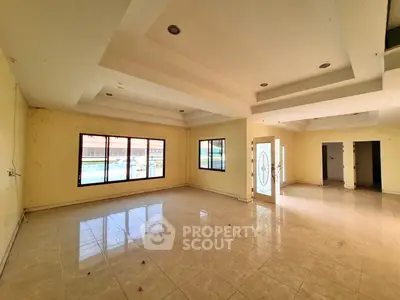 Spacious living room with large windows and elegant ceiling design