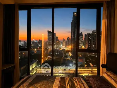 Stunning cityscape view from a modern bedroom window at sunset, showcasing urban living at its finest.