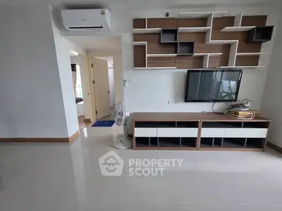 Modern living room with sleek TV unit and air conditioning, showcasing minimalist design.