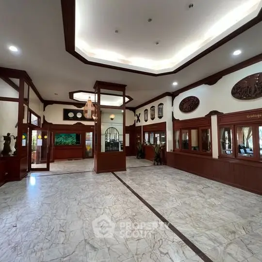 Elegant building entrance with marble flooring and wooden accents