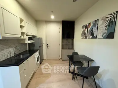 Modern compact kitchen with dining area, featuring sleek cabinetry and contemporary decor.