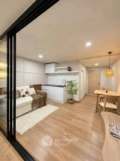 Modern open-plan living room with cozy seating and stylish kitchen area