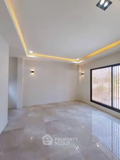 Spacious modern living room with elegant lighting and large window