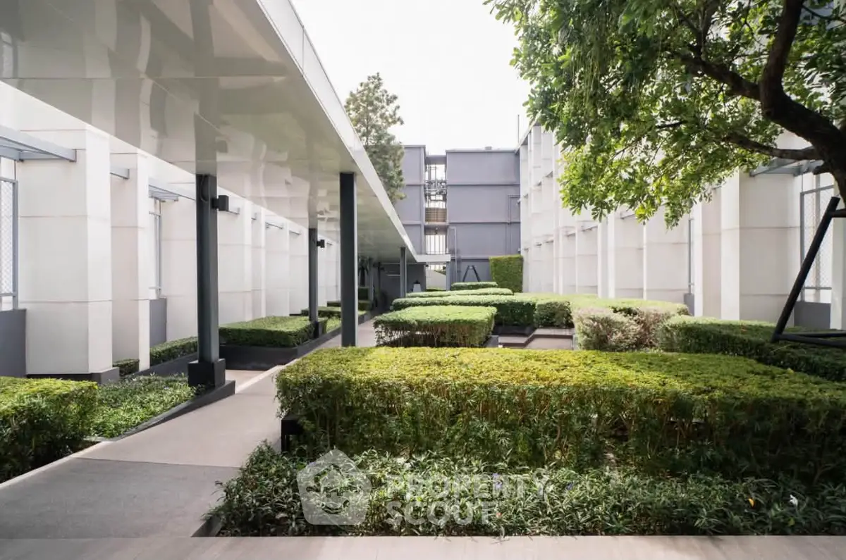 Modern building exterior with lush garden and sleek architectural design