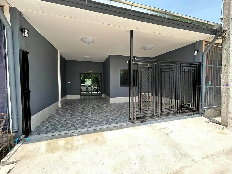 Modern entrance with sleek black gate and spacious tiled area