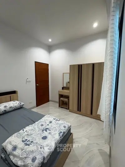 Modern bedroom with stylish furniture and cozy bedding in a well-lit space.