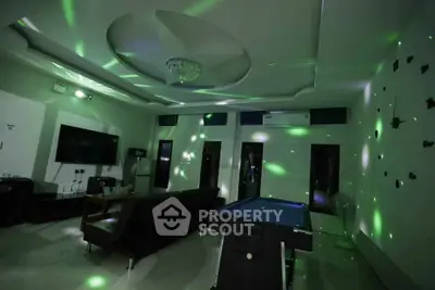 Luxurious living room with pool table and modern lighting, perfect for entertainment and relaxation.