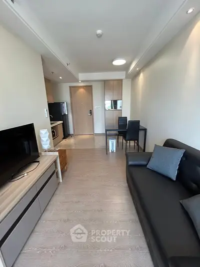 Modern living room with sleek furniture and open kitchen layout in a stylish apartment.
