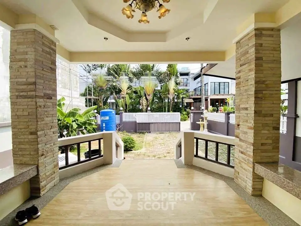 Spacious entrance with elegant stone pillars and lush garden view, perfect for welcoming guests.