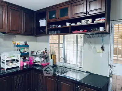 Charming kitchen with dark wood cabinets and sleek black countertops