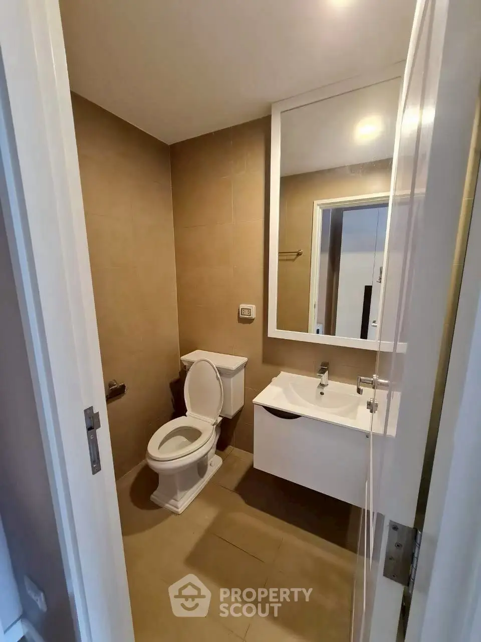 Modern bathroom with sleek fixtures and neutral tones, featuring a wall-mounted sink and contemporary toilet.