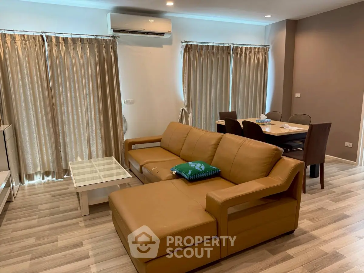 Spacious living room with modern furniture and dining area, perfect for family gatherings.