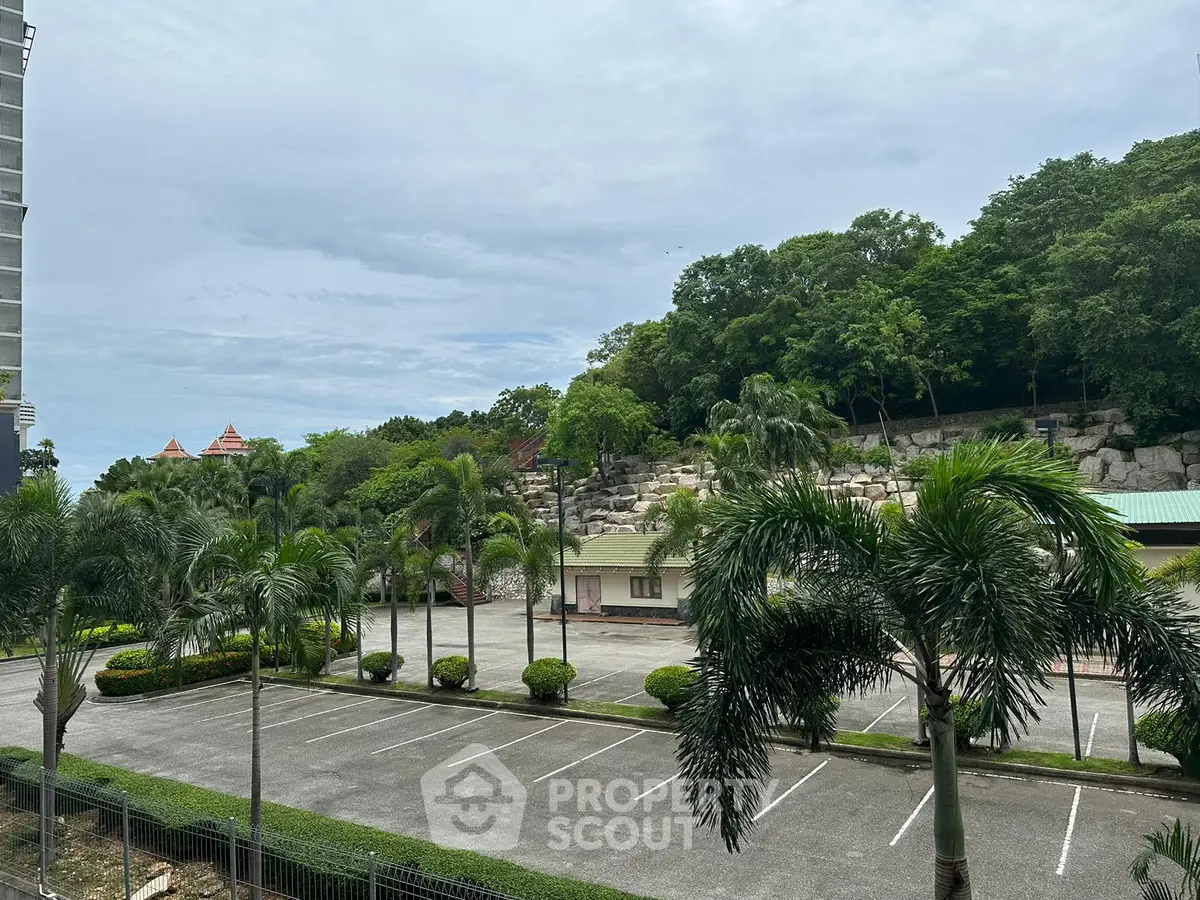 Scenic view of lush greenery and empty parking lot in a serene residential area.