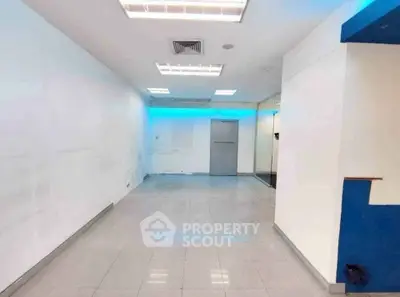 Spacious commercial interior with modern lighting and tiled flooring, ideal for retail or office use.