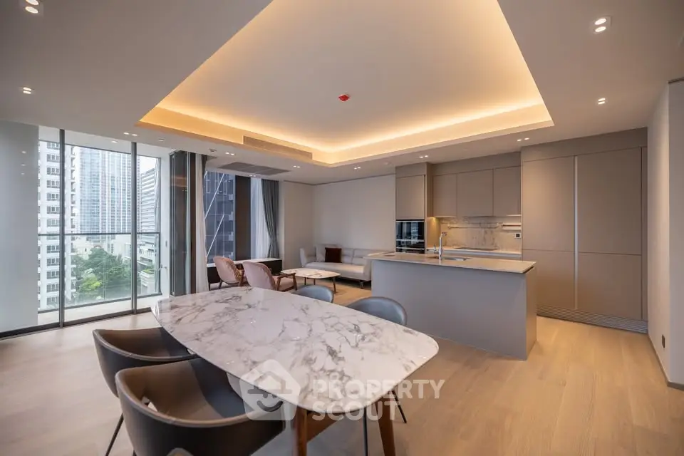 Luxurious open-plan living room with modern kitchen and stunning city view.