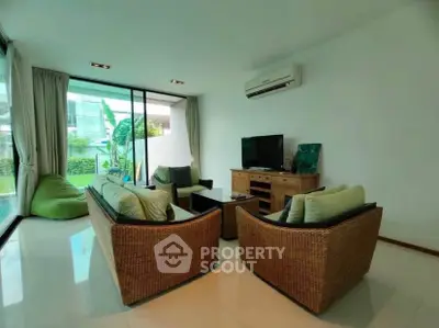 Spacious living room with modern furniture and large windows overlooking garden
