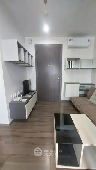 Modern living room with sleek furniture and air conditioning, featuring a stylish TV unit and contemporary decor.