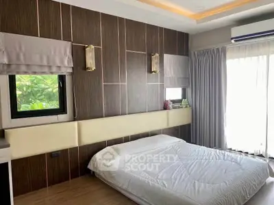 Luxurious bedroom with modern design, featuring elegant wood paneling and large windows for natural light.