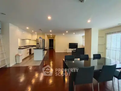 Spacious open-plan living and dining area with modern kitchen and sleek furnishings.