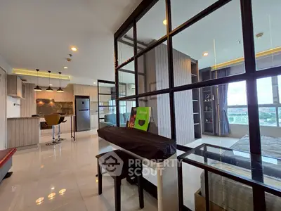 Modern open-plan living space with sleek kitchen and city view, featuring stylish furnishings and ample natural light.