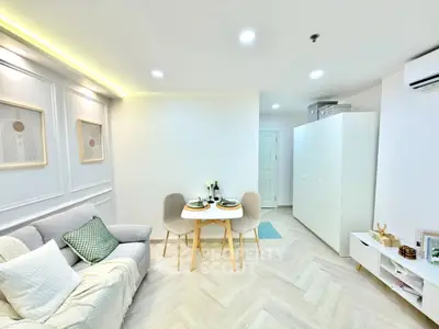 Modern living room with elegant decor and cozy dining area in a stylish apartment.