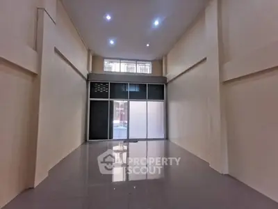 Spacious commercial unit with high ceilings and large front windows, ideal for retail or office space.