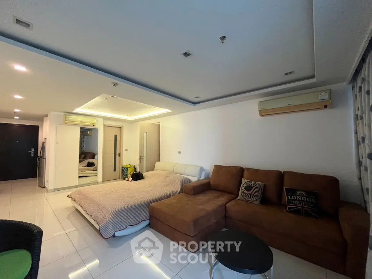 Spacious living room with cozy sofa and bed in modern apartment