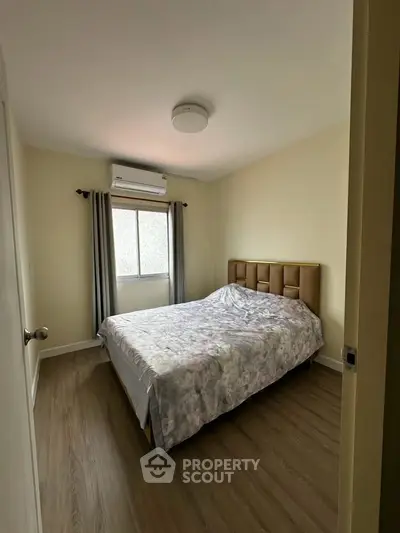 Cozy bedroom with modern decor and natural light, featuring a comfortable bed and stylish flooring.