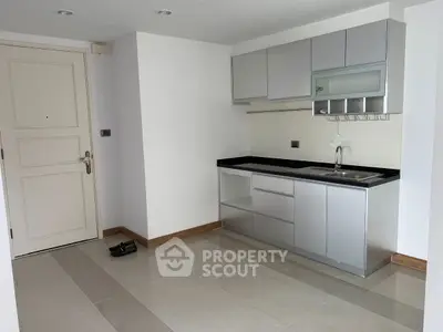 Modern minimalist kitchen with sleek cabinetry and compact design in a bright apartment.