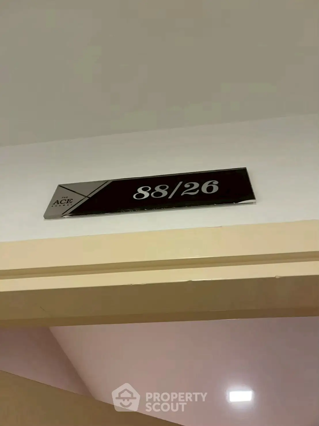 Modern apartment entrance with unit number 88/26 displayed on a sleek sign.